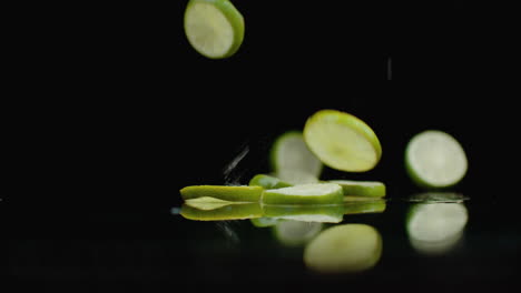 Juicy-fret-slices-fall-on-the-table-with-reflection-and-spray.-Slow-Motion-Green-Lime-Ring.